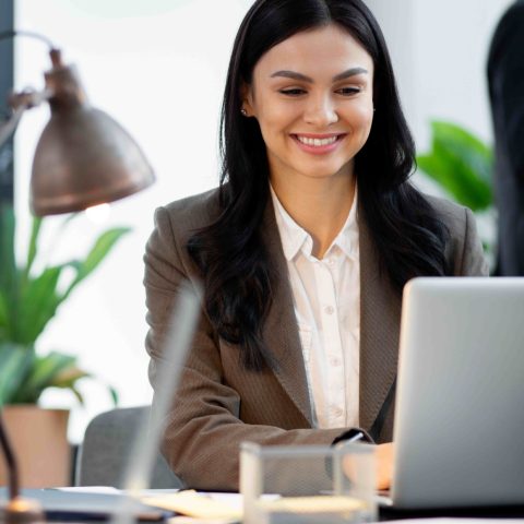 close-up-smiley-woman-working-la (1) (2)